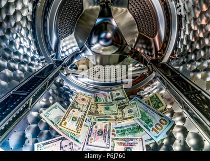 Money laundering symbol, US dollar banknotes in washing machine with the door open Stock Photo