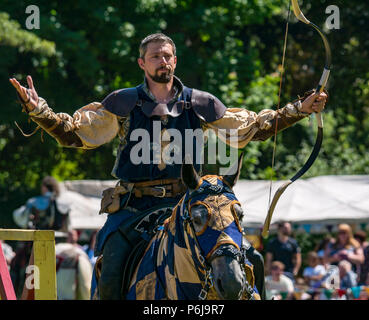 Jousting and Medieval Fair at Linlithgow Palace, Linlithgow, Scotland, United Kingdom, 30th June 2018. Historic Environment Scotland kick off their summer entertainment programme with a fabulous display of Medieval jousting in the grounds of the historic castle. The jousting is performed by Les Amis D'Onno equine stunt team. Knight looks pleased with his archery shot Stock Photo