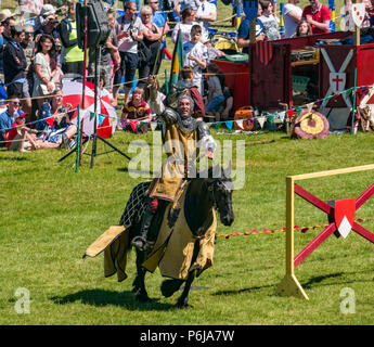 Jousting and Medieval Fair at Linlithgow Palace, Linlithgow, Scotland, United Kingdom, 30th June 2018. Historic Environment Scotland kick off their summer entertainment programme with a fabulous display of Medieval jousting in the grounds of the historic castle. The jousting is performed by Les Amis D'Onno equine stunt team. A knight rides his horse victorious Stock Photo
