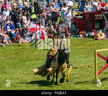 Jousting and Medieval Fair at Linlithgow Palace, Linlithgow, Scotland, United Kingdom, 30th June 2018. Historic Environment Scotland kick off their summer entertainment programme with a fabulous display of Medieval jousting in the grounds of the historic castle. The jousting is performed by Les Amis D'Onno equine stunt team. A knight rides a horse Stock Photo