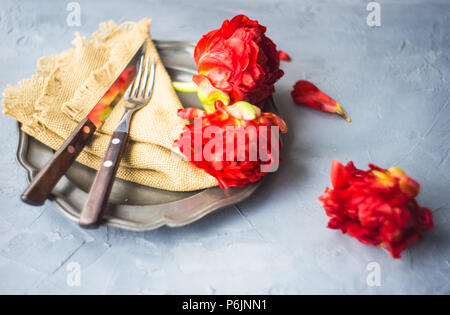 Summer table setting decorated with Red Princess tulips on rustic background Stock Photo