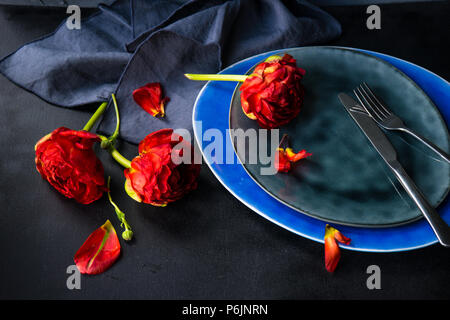 Summer table setting decorated with Red Princess tulips on rustic background Stock Photo