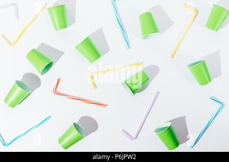 Flat lay pattern decoration of disposable cups and straws. Overhead view composition of summer party utensils of vivid colours on white background wit Stock Photo