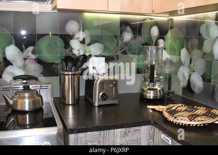 Modern kitchen counter with floral glass backsplash tiles Stock Photo