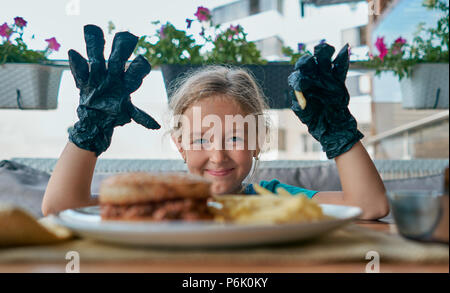 child eats a Burger in a restaurant Stock Photo