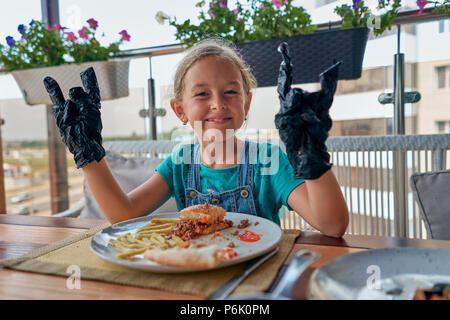 child eats a Burger in a restaurant Stock Photo