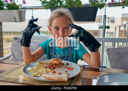 child eats a Burger in a restaurant Stock Photo