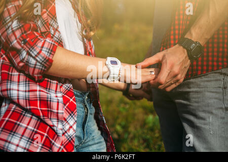 Hiker young woman holding man's hand on nature outdoor. Couple in love, focus in hands Stock Photo