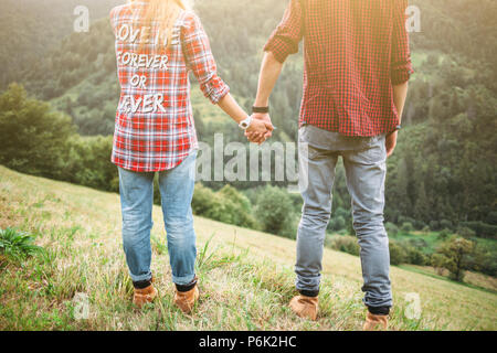 Hiker young woman holding man's hand on nature outdoor. Couple in love Stock Photo