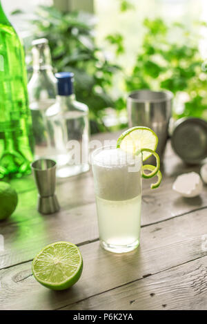 Egg Gin Fizz Cocktail with Lime Garnish. Making Gin Fizz Drink with ingredients. Stock Photo