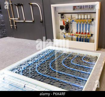 Floor heating distributor, exhibition sample in the store. Mounting or installation scheme, warm house control Stock Photo