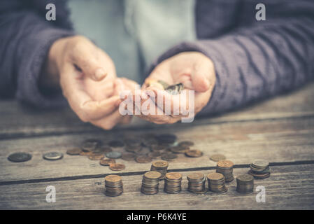 Money, coins, the grandmother on pensions and a concept of a living minimum old woman sadly counts not enough money, vintage Stock Photo