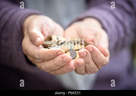 Money, coins, the grandmother on pension and the concept of life, minimum - in hands old a handful of coins. Close up Stock Photo