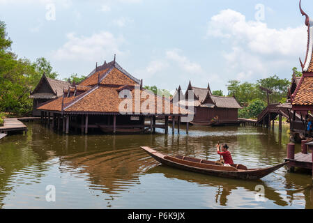 Laem Chabang, Thailand -- March 16, 2016. Woman paddles a long-tail boat in Thai water markets. Stock Photo