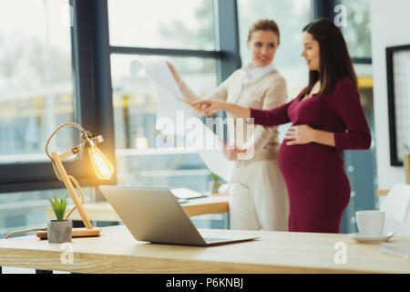 Clever engineers looking at schemes and talking Stock Photo
