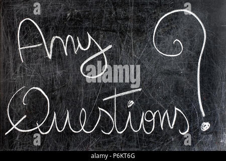 Any questions question handwritten with white chalk on dirty blackboard Stock Photo