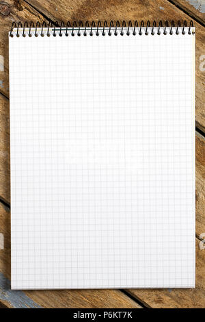 White spiral squared notebook on rustic wooden table viewed from above Stock Photo