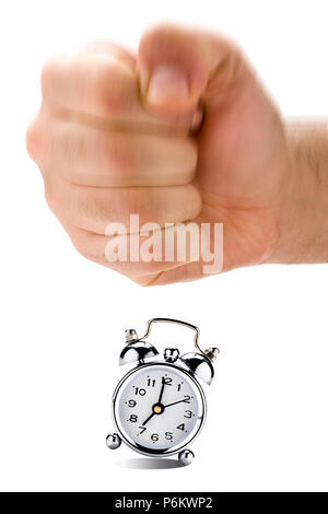 Big hand in a fist is about to hit vintage clock alarm Stock Photo