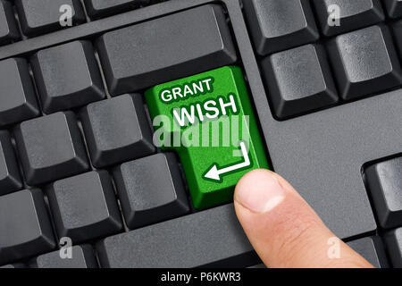 Top view of black keyboard with Enter key replaced with grant wish green Key that is about to be pressed by male finger Stock Photo