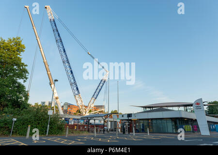 Telford Central Station, Telford, Shropshire, UK, Sunday July 1st 2018.  One of Europe's largest mobile cranes lifts a new section of railway footbridge into place over the railway line next to the A442 Queensway Road, Telford.  The 95 ton Liebherr LG1750 mobile crane lifed the first crossing section onto it's mounts in the early hours of Sunday morning 1st July 2018.  The civil engineering project is replacing the original footbridge at a cost of around £10 million. Credit: AMD Images/Alamy Live News Stock Photo