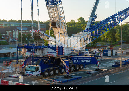 Telford Central Station, Telford, Shropshire, UK, Sunday July 1st 2018.  One of Europe's largest mobile cranes lifts a new section of railway footbridge into place over the railway line next to the A442 Queensway Road, Telford.  The 95 ton Liebherr LG1750 mobile crane lifed the first crossing section onto it's mounts in the early hours of Sunday morning 1st July 2018.  The civil engineering project is replacing the original footbridge at a cost of around £10 million. Credit: AMD Images/Alamy Live News Stock Photo