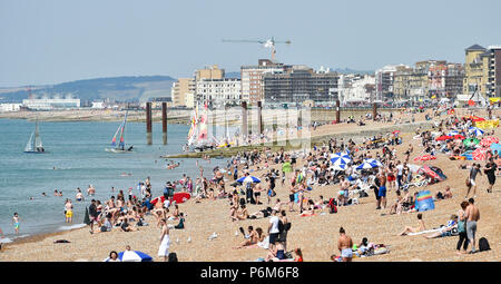 Brighton UK 1st July 2018  - Crowds flock to Brighton beach as the heatwave continues throughout Britain with thunderstorms forecast for some parts of the UK Credit: Simon Dack/Alamy Live News Stock Photo