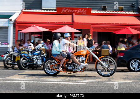 Southend on Sea, Essex, UK. The warm spell has continued in Southend. A chopper custom motorcycle with rider and female pillion wearing shorts Stock Photo