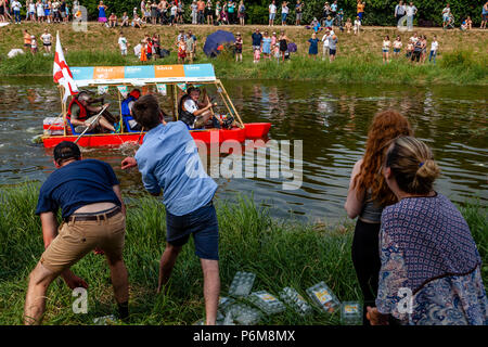 Local people take part in the long standing tradition of throwing eggs at the home made rafts taking part in the annual Ouseday Raft Race held on the River Ouse In Lewes, Sussex, UK Stock Photo