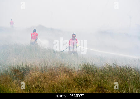 Lancashire, UK. 1 July 2018 - Firefighters attempt to control the growing moorland fire on Winter Hill and Rivington Pike which was started a number of days ago. Fire crews from across the UK have converged on Winter Hill to control the blaze which is growing by metres per hour. Lancashire Fire and Rescue and Lancashire Police are leading the response to the 'major incident'. Credit: Benjamin Wareing/17�Թ����� Live News Stock Photo