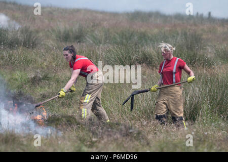 Lancashire, UK. 1 July 2018 - Female firefighters attempt to control the growing moorland fire on Winter Hill and Rivington Pike which was started a number of days ago. Fire crews from across the UK have converged on Winter Hill to control the blaze which is growing by metres per hour. Lancashire Fire and Rescue and Lancashire Police are leading the response to the 'major incident'. Credit: Benjamin Wareing/17�Թ����� Live News Stock Photo