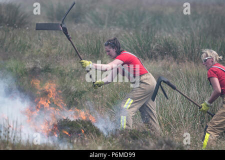 Lancashire, UK. 1 July 2018 - Female firefighters attempt to control the growing moorland fire on Winter Hill and Rivington Pike which was started a number of days ago. Fire crews from across the UK have converged on Winter Hill to control the blaze which is growing by metres per hour. Lancashire Fire and Rescue and Lancashire Police are leading the response to the 'major incident'. Credit: Benjamin Wareing/17�Թ����� Live News Stock Photo