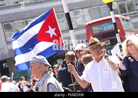 London, UK - 30 June 2018: A demonstrator holding a Cuban flag joined the thousands of people taking part in a national demonstration and celebration to mark the 70th anniversary of the NHS on 30 June. The demonstration organised by  The People's Assembly amongst other seek for A publicly owned NHS that is free for all and proper funding and proper staffing.  Credit:  David Mbiyu / Alamy Live News Stock Photo