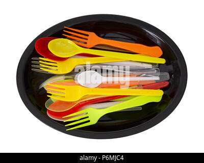 Plastic knives, forks and spoons on black plate isolated on white. Stock Photo