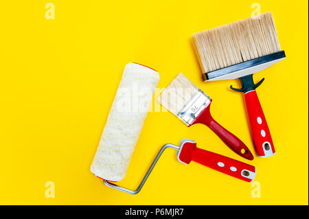 Top view of professional house painter work tools on a yellow desk Stock Photo