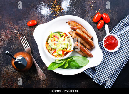 grilled sausages with salad on white plate, stock photo Stock Photo