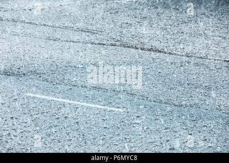 city road flooded during heavy rain. raindrops on water puddles. bad weather Stock Photo