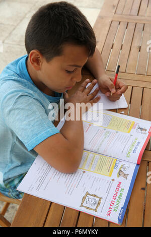 11-year-old boy doing homework in Salento, Italy. Stock Photo