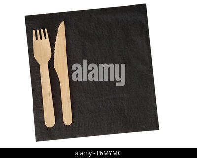 Wooden disposable cutlery on black serviette. Isdolated on white. Ecofriendly. Stock Photo
