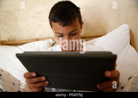 11-year-old boy using a digital tablet in Salento, Italy. Stock Photo