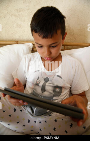 11-year-old boy using a digital tablet in Salento, Italy. Stock Photo