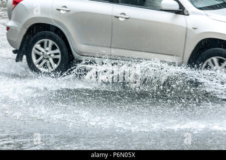 car traffic during rainy day. splashes of water from car wheels Stock Photo