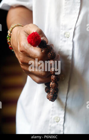 A man praying Mala beads, the Buddhist prayer beads. Close-up.  Cai be. Vietnam. Stock Photo