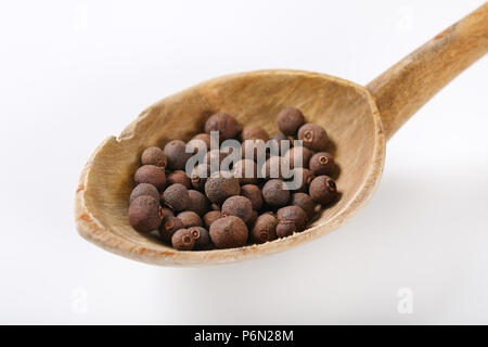 spoon of whole allspice berries on white background Stock Photo