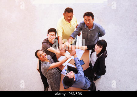 Business People Teamwork Meeting joining hands in office concept, Using Ideas, Charts, Computers, Tablet, Smart devices on business planning the table Stock Photo