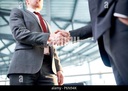 Two businessmen shaking hands to each other at office Stock Photo