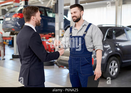 Car Mechanic Giving Keys to Businessman Stock Photo