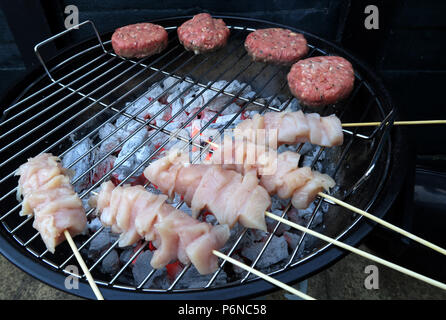 Raw Chicken,on a BBQ,raw Chicken,uncooked meat,over charcoal on a garden grill,summer BBQ Stock Photo