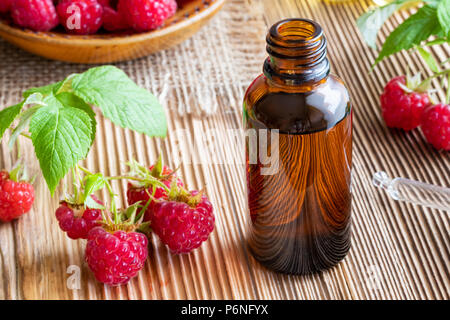 A bottle of raspberry seed oil on a table Stock Photo