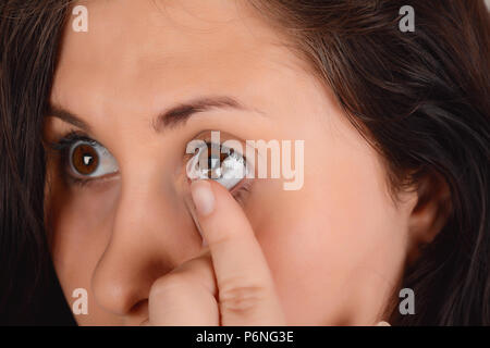 Closeup Of Female Face With Applying Contact Lens On Her Brown Eyes. Opthalmology Medicine concept. Stock Photo