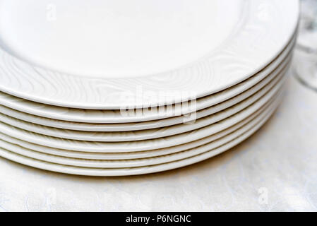 Stack of clean white plates on table Stock Photo